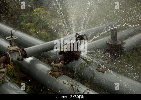 Accident de pipeline. L'eau bouillante coule du tuyau. Urgence de la chaufferie. Situation industrielle. Banque D'Images