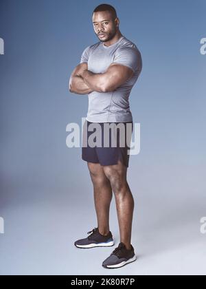 Je suis toujours prêt pour le prochain défi. Photo en longueur d'un beau jeune homme debout seul dans le studio avec ses bras repliés. Banque D'Images