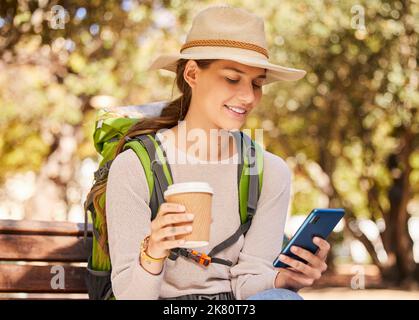 Téléphone, café et Voyage avec une femme routard utilisant la technologie mobile 5g pour les directions ou la navigation dans un parc. Médias sociaux, tourisme et Banque D'Images