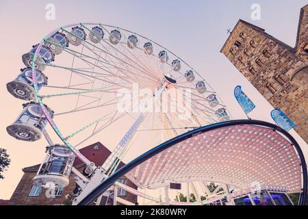 24 juillet 2022, Osnabruck, Allemagne: Coucher de soleil vue de parc d'attractions et de divertissement avec roue de ferris près de la cathédrale dans le centre historique de la ville Banque D'Images