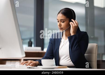 Gestion des jours d'appels entrants. Jeune femme d'affaires travaillant sur un ordinateur dans un centre d'appels. Banque D'Images