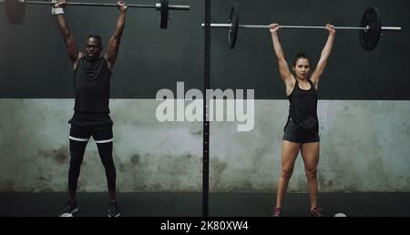 La cohérence produit des résultats ultimes. Portrait d'un jeune homme et d'une femme faisant une presse au pavillon avec une barbell dans une salle de sport. Banque D'Images