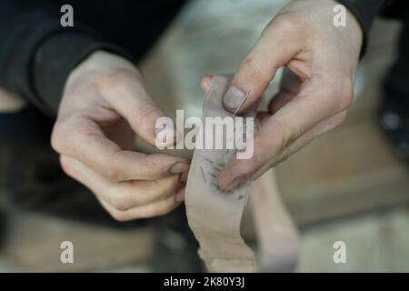 Ruban à coudre. Surpiqûres sur le col dans l'armée. Travail de weaver. Réparer les vêtements avec vos propres mains. Banque D'Images