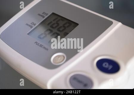 L'écran d'un moniteur de pression artérielle numérique électronique affiche les valeurs de pression supérieure (systolique) et inférieure (diastolique) Banque D'Images