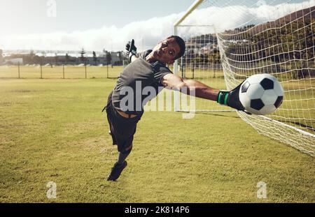 Football, sport et entraînement de gardien de but sur un terrain pour une compétition professionnelle. Jeune et forte athlète avec l'énergie et la motivation de prendre un Banque D'Images
