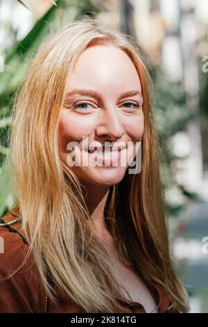 portrait vertical d'une femme caucasienne attrayante et gaie. Elle regarde l'appareil photo et sourit. Banque D'Images
