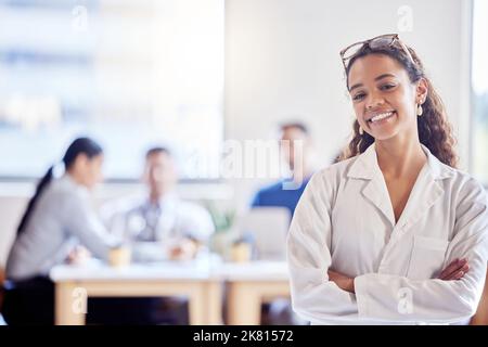 Votre santé est ma priorité. Une jeune femme médecin debout avec ses bras a traversé un bureau au travail. Banque D'Images