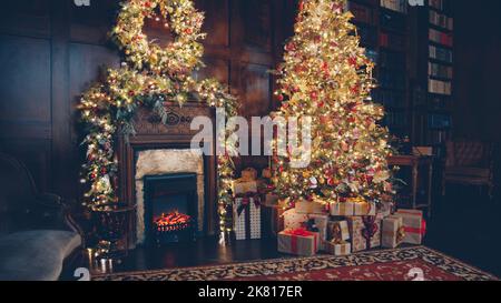 Belle chambre confortable avec arbre de Noël décoré, cadeaux et cheminée le jour de l'an, aucune personne n'est visible. Concept de la maison et des célébrations. Banque D'Images