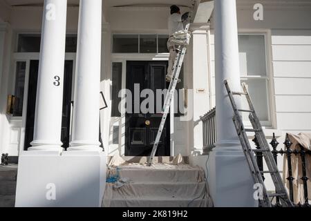 Un entrepreneur en décoration peint l'extérieur d'une propriété blanche à South Kensington, le 19th octobre 2022, à Londres, en Angleterre. Banque D'Images