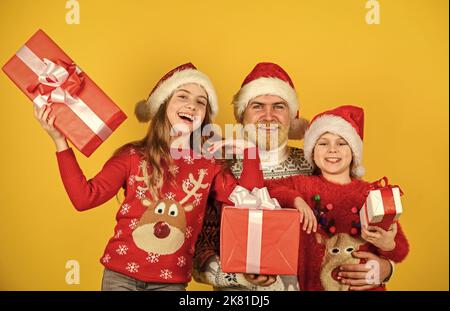 Cadeaux pour tout le monde. Le père et les petites filles célèbrent ensemble la nouvelle année. Noël devient spécial avec les enfants. Concept de la veille de Noël Banque D'Images