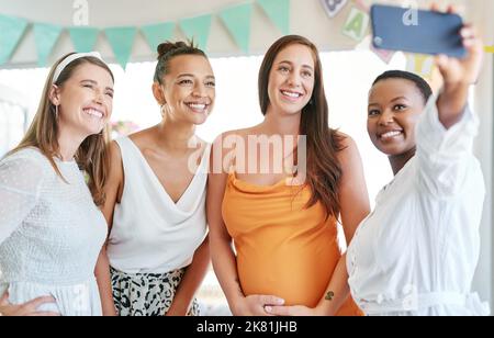 Avoir tous dans ma vie est une bénédiction. Un groupe d'amis féminins prenant des selfies à une douche de bébé. Banque D'Images