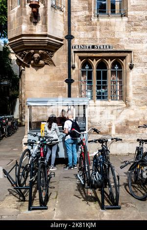 Un couple commandant une glace sur un stand de glace à côté d'un stand de vélo sur Trinity Street, Cambridge, Royaume-Uni Banque D'Images