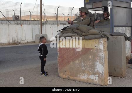 NAPLOUSE, CISJORDANIE - OCTOBRE 19 : les soldats israéliens gardent derrière des blocs de béton tandis qu'un jeune garçon palestinien montre la carte d'identité de ses parents au point de contrôle militaire Beit Furik sur 19 octobre 2022, situé à l'entrée est de Naplouse, en Cisjordanie. Les forces israéliennes ont imposé un blocus continu sur la zone autour de Naplouse, dans un contexte de tensions accrues en Cisjordanie qui restreignent le mouvement d'environ 420 000 Palestiniens. Crédit : Eddie Gerald/Alay Live News Banque D'Images