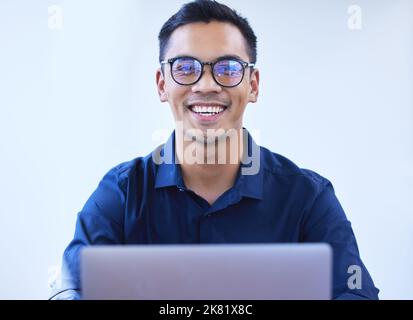 Je me sens plus confiant dans mon succès aujourd'hui. Portrait d'un jeune homme d'affaires travaillant sur un ordinateur portable dans un bureau. Banque D'Images