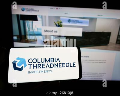 Personne tenant un smartphone avec le logo de la société américaine Columbia Threadneedle Investments sur l'écran devant le site Web. Mise au point sur l'affichage du téléphone. Banque D'Images