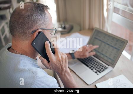Oui, je vois quelques erreurs sur cette feuille de calcul. Un homme mûr utilisant son smartphone pour passer un appel. Banque D'Images