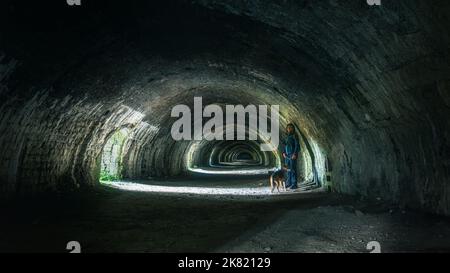 À l'intérieur de l'ancien four Hoffman Lime au Craven Lime Works avec une personne et un chien à Stainforth dans les Yorkshire Dales. ROYAUME-UNI Banque D'Images