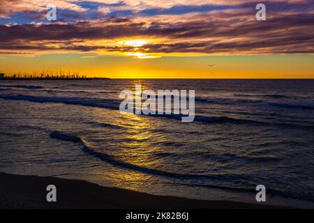 Incroyablement beau meilleur lever de soleil orange sur la mer Méditerranée à Sitges. Mer, ciel avec nuages, oiseaux et horizon Banque D'Images