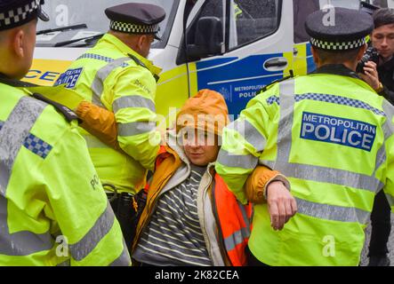 20 octobre 2022, Londres, Angleterre, Royaume-Uni: La police arrête un manifestant. Les activistes Just Stop Oil ont collé leurs mains et se sont attachés à des tuyaux métalliques sur Brompton Road à l'extérieur de Harrods, et ont pulvérisé de la peinture orange sur les fenêtres du célèbre grand magasin de Knightsbridge, alors qu'ils poursuivent leurs protestations exigeant que le gouvernement cesse d'émettre de nouvelles licences de combustibles fossiles. (Image de crédit : © Vuk Valcic/ZUMA Press Wire) Banque D'Images