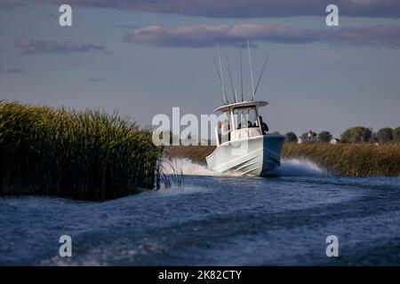 Un bateau de moteur qui traverse un petit canal. Banque D'Images