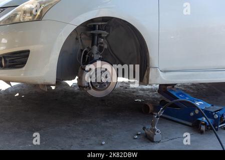 Changer un pneu de voiture causé par un pneu crevé en utilisant un cric pour soulever la voiture. Banque D'Images