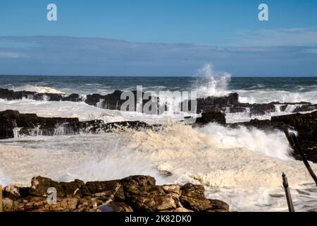 Des vagues écrasantes contre des rochers en saillie sur le rivage Banque D'Images