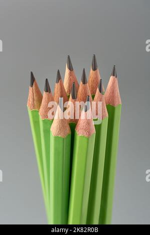 gros plan d'un groupe de crayons, crayons en bois de couleur verte aiguisée non utilisés isolés sur fond gris neutre, doux-focus Banque D'Images