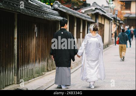 Un couple japonais le jour de leur mariage vêtu de kimono traditionnel prenant des photos à kyoto Banque D'Images