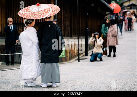 Un couple japonais le jour de leur mariage vêtu de kimono traditionnel prenant des photos à kyoto Banque D'Images