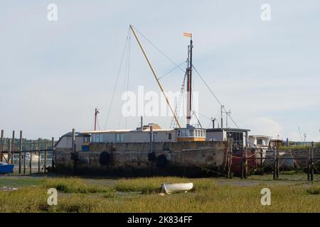 La rivière Orwell amarrait des bateaux à marée basse avec des barges en béton au premier plan Banque D'Images