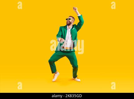 Drôle de jeune gars en costume vert dansant et s'amuser à la fête de la Saint Patrick Banque D'Images
