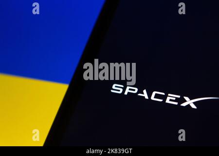 Vancouver, CANADA - octobre 19 2022 : gros plan du logo SpaceX sur un iPhone sur fond de drapeau ukrainien Banque D'Images