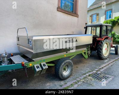 Ribeauville, France - 22 septembre 2022 : vue arrière du chariot de vendange en acier inoxydable Mosella chariot de vendange attaché au tracteur rouge dans la partie cérale du village - la route des vins d'Alsace Banque D'Images