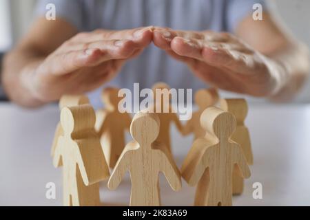 Femme couvrant ses personnages en bois de palmier de personnes les protégeant, concept de pièce du monde. Banque D'Images