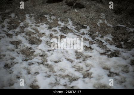 Neige sale par la route. Côté de route en hiver. Les blocs de glace sont noirs. Déneigement. Banque D'Images
