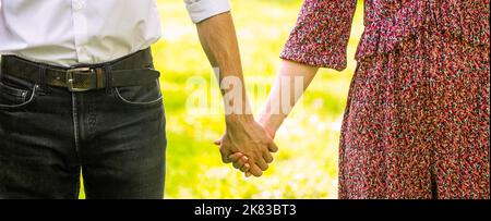 Coup de main. Ouple amoureux marchant dans le parc tenant main. Tenez-vous, mains, couple. Couple tenant les mains le jour du soleil. Couple tenant Banque D'Images