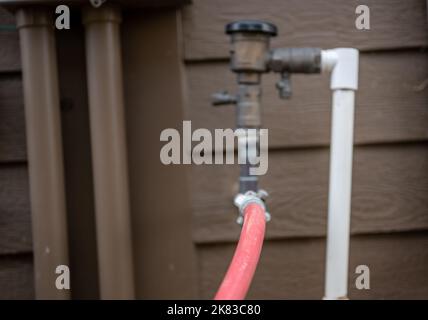 Hivernage d'un système d'irrigation résidentiel à l'aide d'un compresseur et d'air forcé pour souffler les conduites vides. Banque D'Images