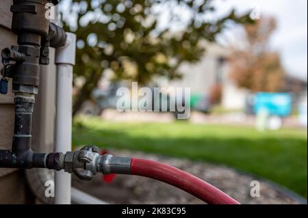 Hivernage d'un système d'irrigation résidentiel à l'aide d'un compresseur et d'air forcé pour souffler les conduites vides. Banque D'Images