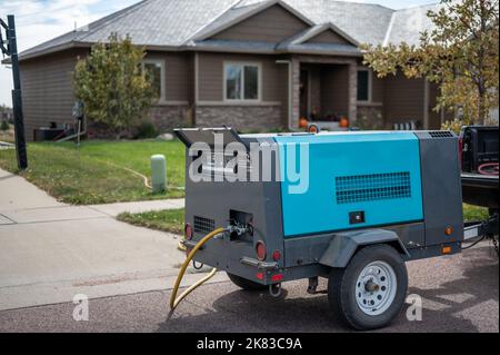 Hivernage d'un système d'irrigation résidentiel à l'aide d'un compresseur et d'air forcé pour souffler les conduites vides. Banque D'Images