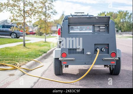 Hivernage d'un système d'irrigation résidentiel à l'aide d'un compresseur et d'air forcé pour souffler les conduites vides. Banque D'Images