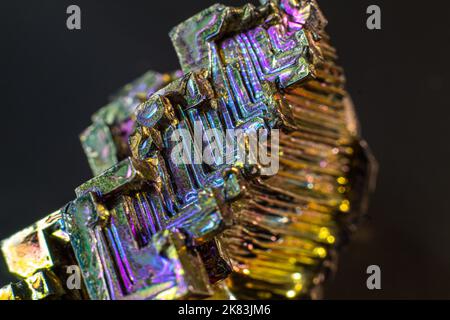 Bismuth bi gros plan sur une surface noire.cristal de couleur et de forme intéressant. Cristal métallique Banque D'Images