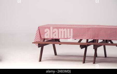 Table en bois et serviette rouge pour les fêtes en plein air et fond blanc. Banque D'Images