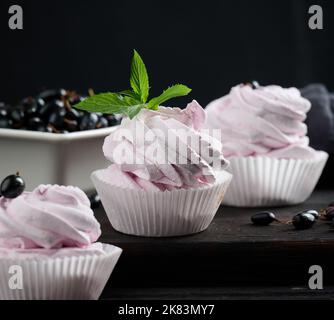 Marshmallows aux fruits martionnés dans une tasse en papier sur un plateau en bois noir, délicieux dessert Banque D'Images