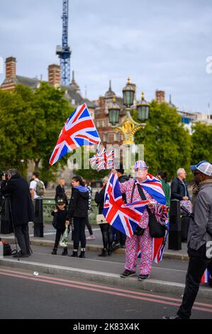 Londres - 19 septembre 2022 : un homme vêtu de drapeaux de l'Union Jack vend des souvenirs de l'Union Jack sur le pont de Westminster Banque D'Images