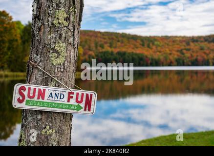 Parfaitement calme Silver Lake à Barnard Vermont avec humoristique Jump dans le lac signe sur l'arbre Banque D'Images