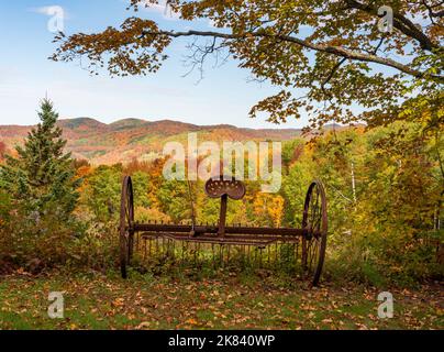 Équipement agricole rouillé de rateau ou de charrue sur des collines aux couleurs automnales dans le Vermont Banque D'Images