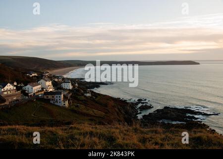 North Devon bord de mer au coucher du soleil. Large vue sur la côte de Woolacombe, Angleterre avec falaises, rochers et vagues Banque D'Images