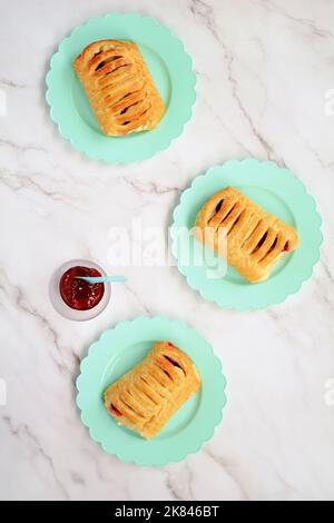 Croissants frais aux fraises et au fromage à la crème sur des assiettes de pétale d'aqua. Prise de vue en hauteur au format vertical. En-cas savoureux. Banque D'Images