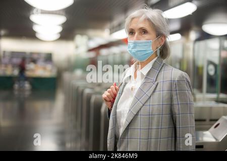 Femme âgée dans un masque à l'entrée de la station de métro Banque D'Images