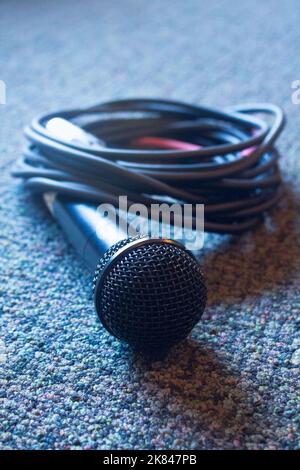 Microphone avec câble sur moquette. Banque D'Images